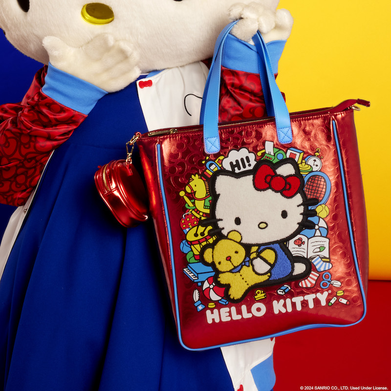 Hello Kitty holding the Loungefly Sanrio Hello Kitty 50th Anniversary Metallic Tote Bag with Coin Bag, her other hand covering her mouth as she stands against a red and yellow background 